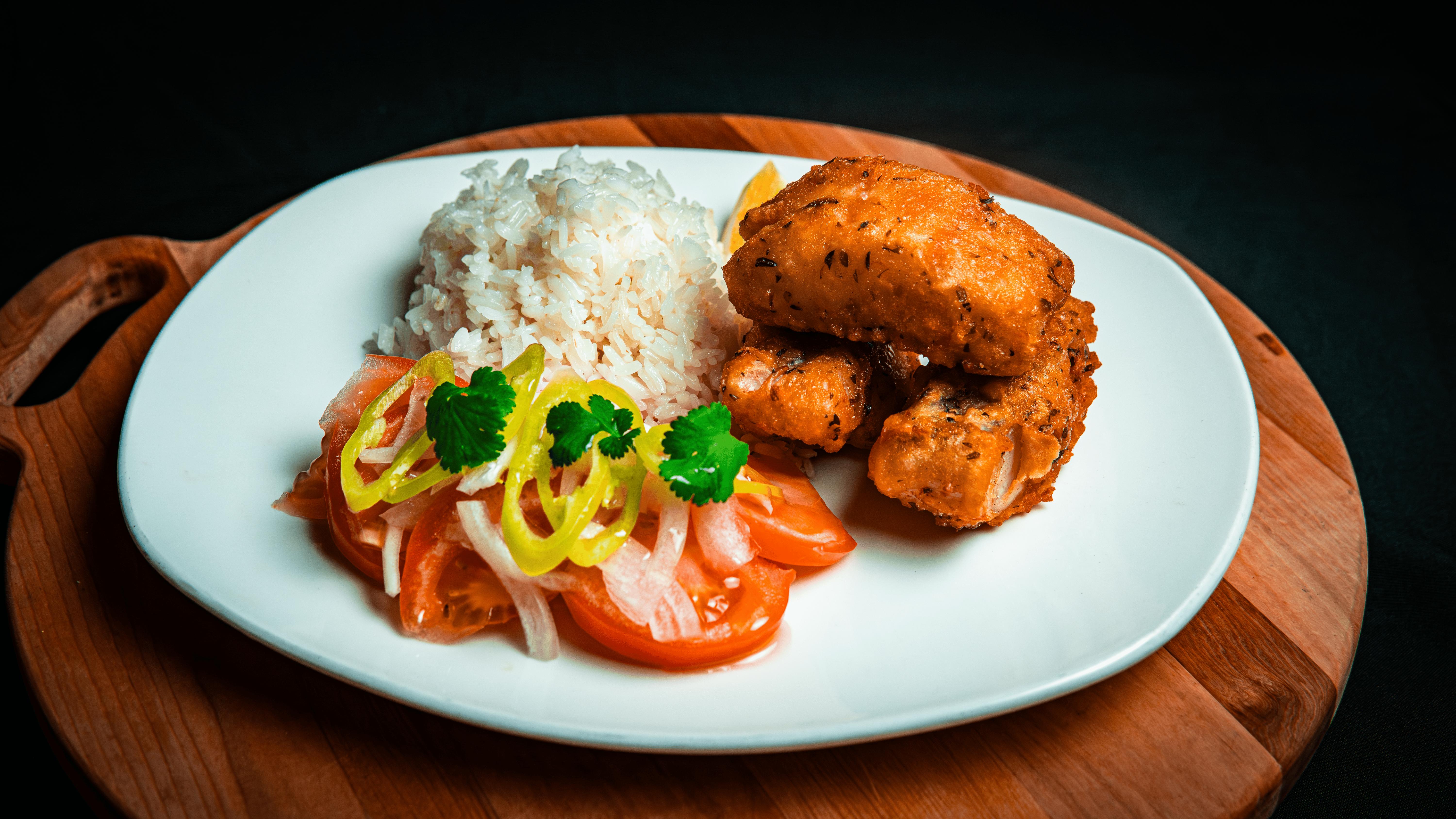 Demostración de cocinería ficticia: pescado frito acompañado de arroz y ensalada
