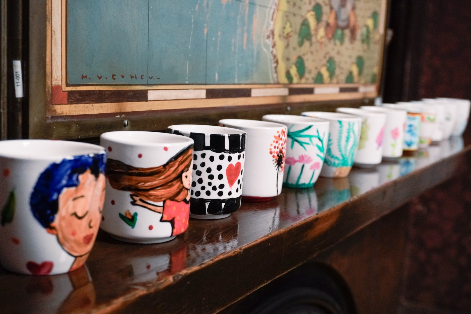 Colección de tazones pintados por participantes, alineados sobre un mueble de madera