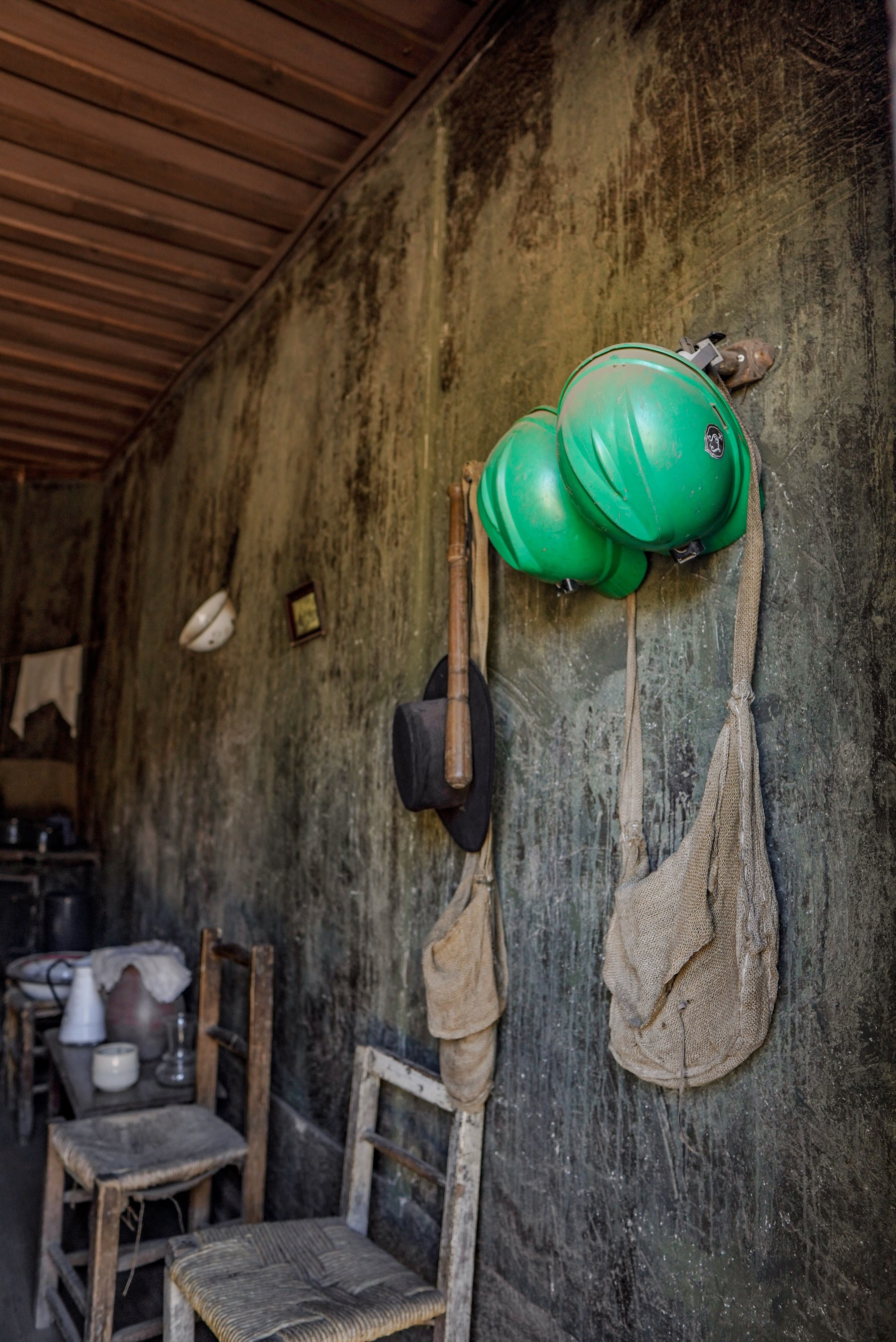 Cascos mineros colgados en una vivienda recreada